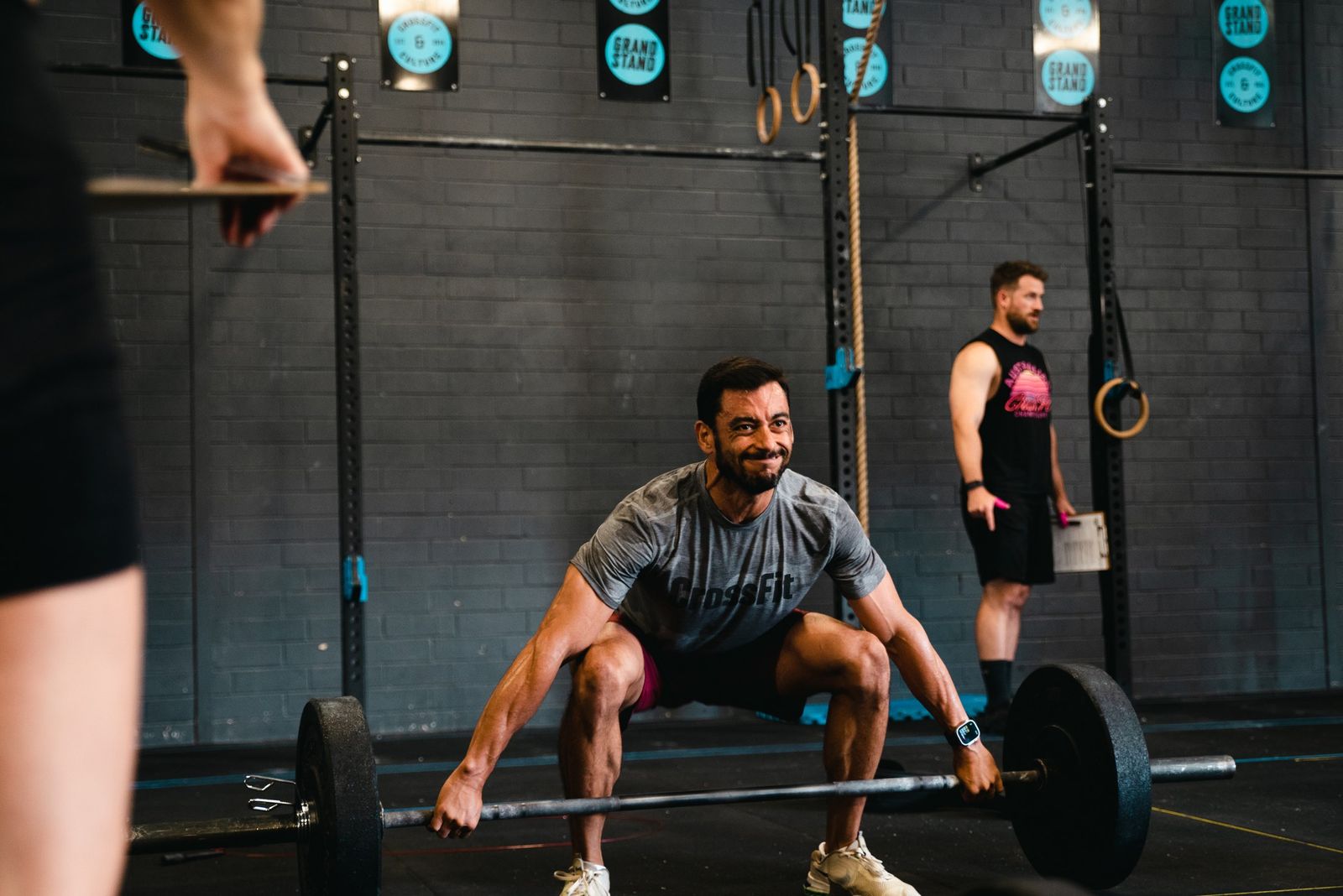 Smiling member mid-deadlift in a coached CrossFit class at Grandstand Perth