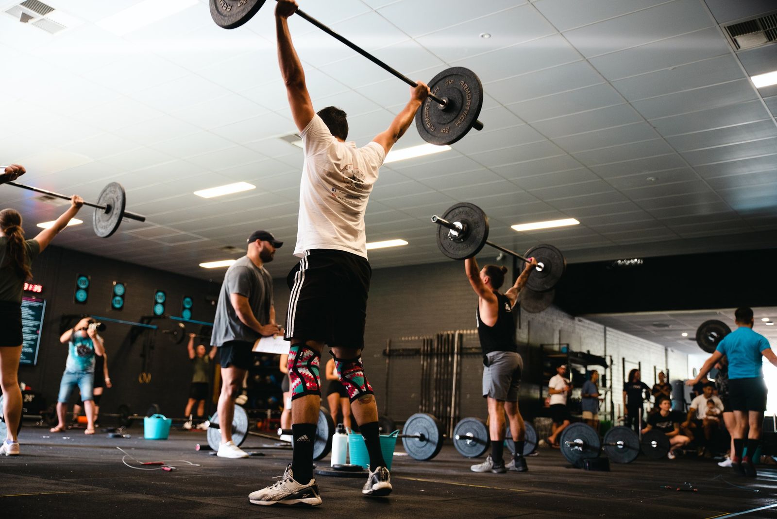 Grandstand members lifting barbells across the open gym floor in Perth